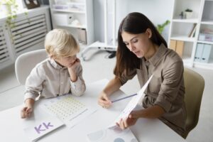 woman-doing-speech-therapy-with-little-blonde-boy